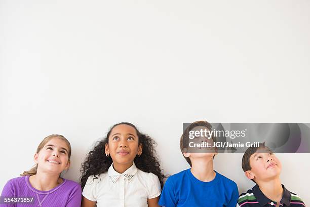 smiling children thinking and looking up - children thinking fotografías e imágenes de stock