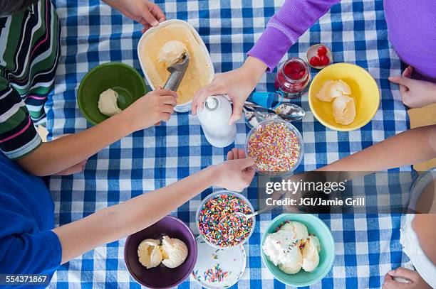 high angle view of children making ice cream sundaes - kirschen tisch weiß stock-fotos und bilder