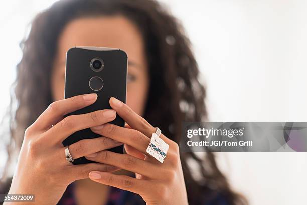 close up of mixed race woman using cell phone - obscured face phone stock pictures, royalty-free photos & images