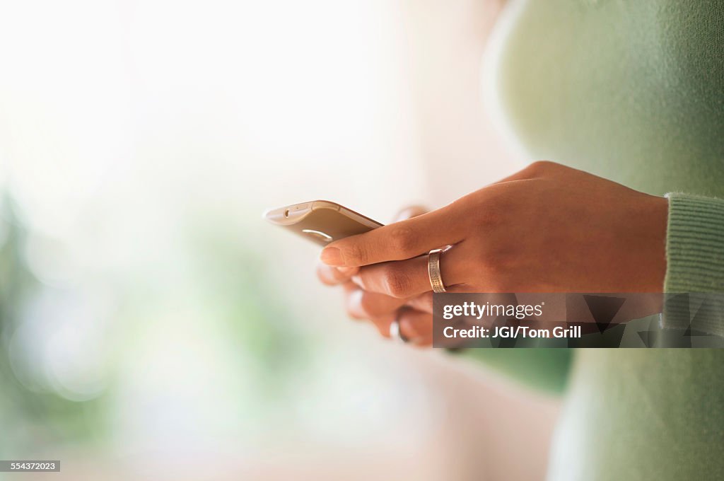 Close up of mixed race woman using cell phone