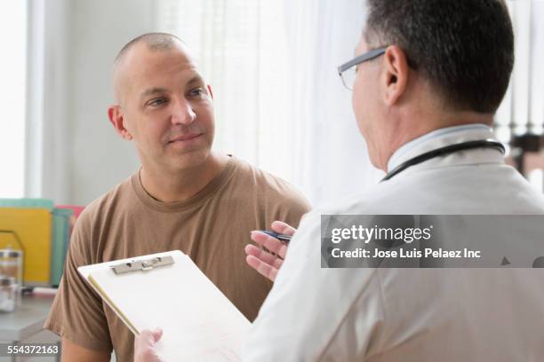 caucasian soldier and doctor talking in office - military man stock pictures, royalty-free photos & images