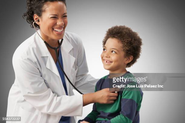 doctor listening to chest of boy - stethoscope child stock pictures, royalty-free photos & images