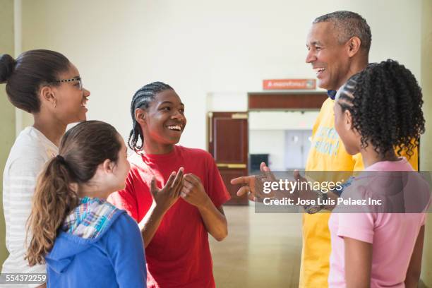 volunteer talking to children in community center - 13 reasons why stock-fotos und bilder