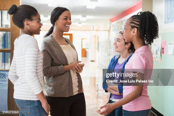 teacher talking to children in school hallway - jamaican girl stock pictures, royalty-free photos & images