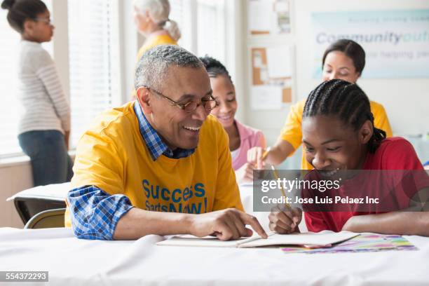 volunteers tutoring students in classroom - community work day stock pictures, royalty-free photos & images