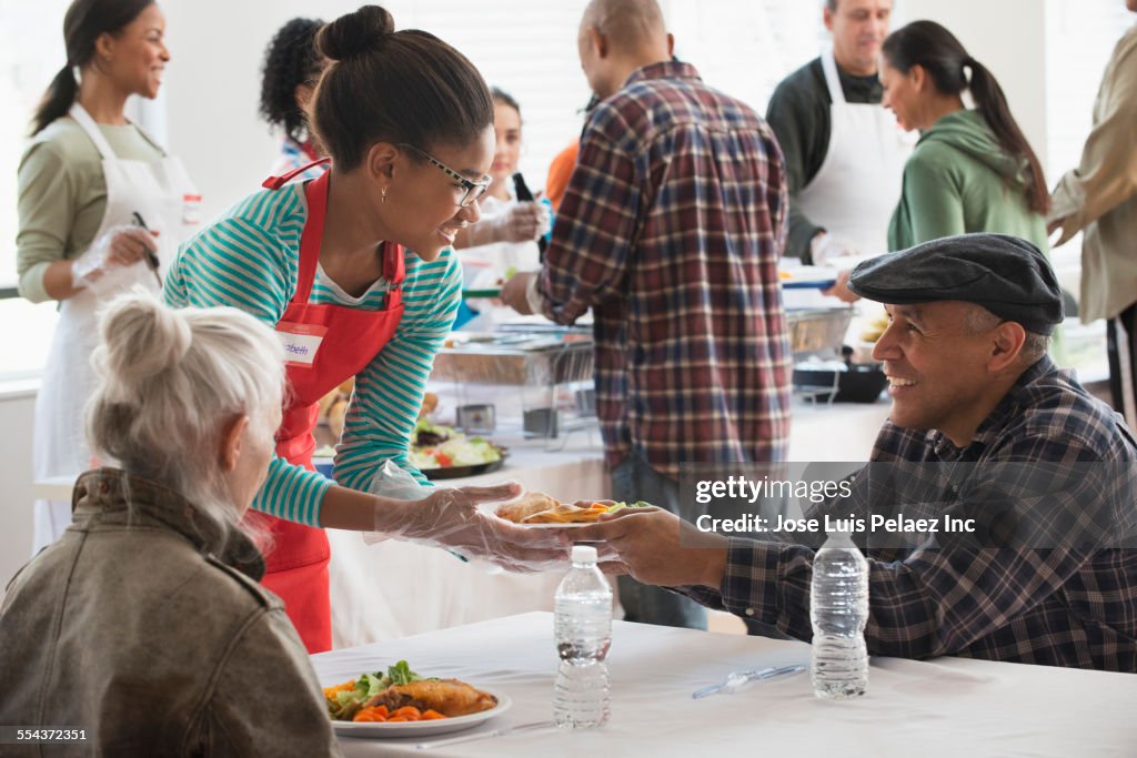 Volunteer serving food at community kitchen