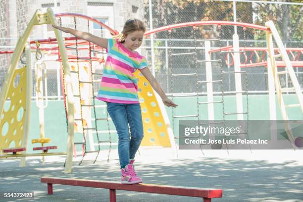 caucasian girl walking on balance beam in park - playground balance beam stock pictures, royalty-free photos & images