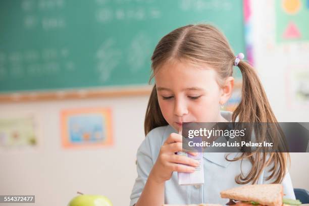 caucasian student drinking juice box in classroom - juice box stock pictures, royalty-free photos & images