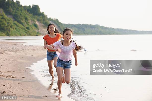 chinese girls playing on beach - running toronto stock-fotos und bilder