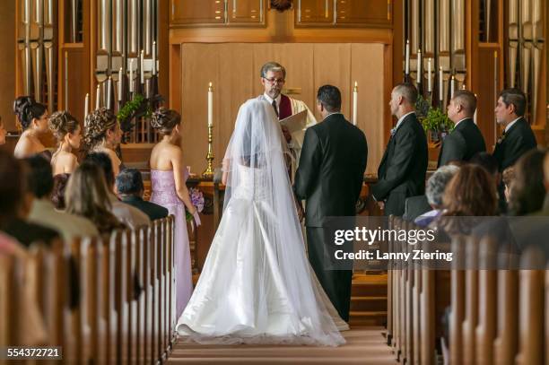 bride and groom standing at altar during wedding ceremony - altar stock-fotos und bilder