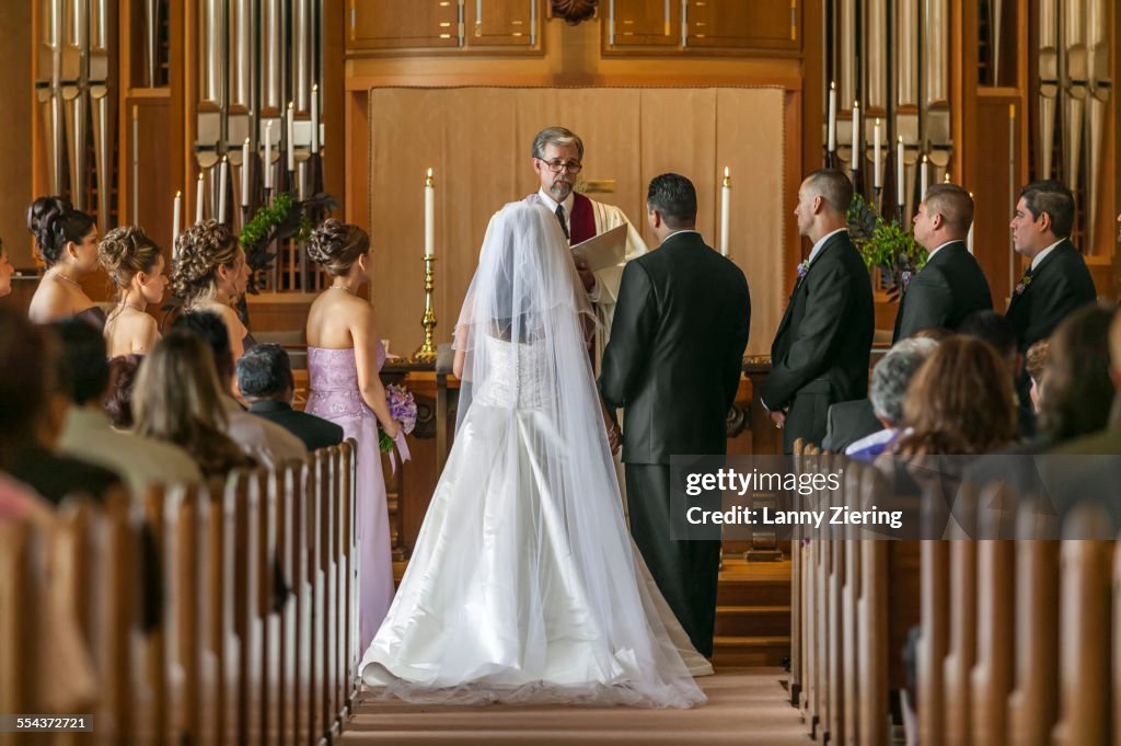 Bride and groom standing at altar during wedding ceremony