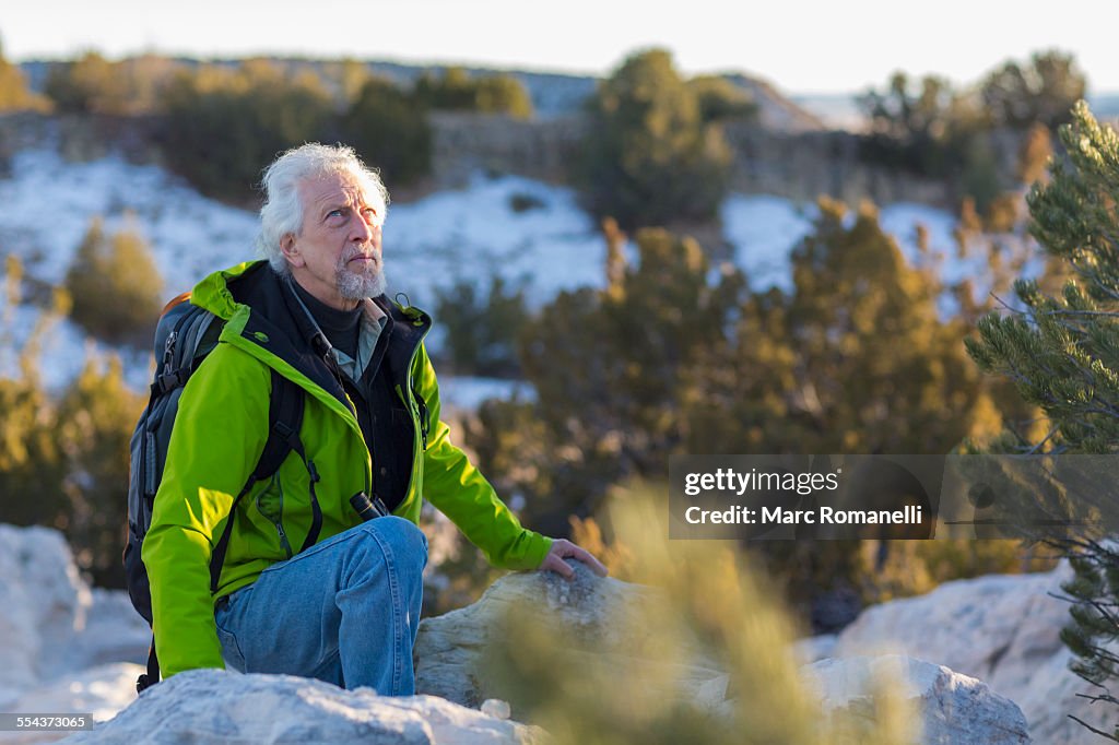 Older man standing on rock formations