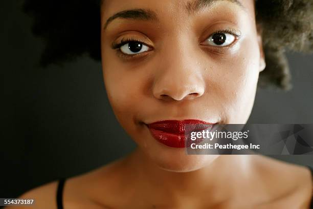 close up of black woman smirking - sospecha fotografías e imágenes de stock