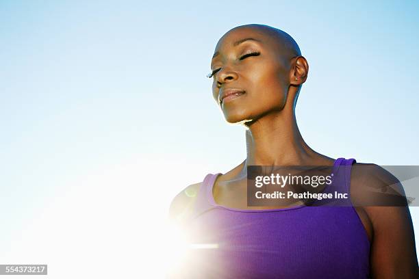 african american woman smiling in sunburst under blue sky - hair loss in woman stock pictures, royalty-free photos & images