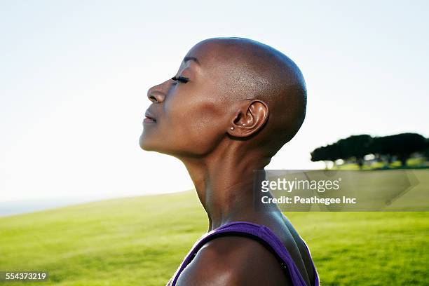 profile of african american woman smiling in park - hair loss stock pictures, royalty-free photos & images
