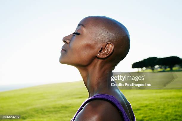 profile of african american woman smiling in park - hair loss in woman stock pictures, royalty-free photos & images