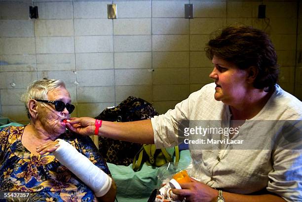 Sally McKenzie administers medicine to her mother, Estelle, who took refuge at the Jackson Convention Center on September 1, 2005 in Jackson,...