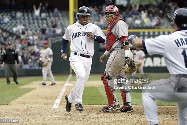 Ramon Santiago of the Seattle Mariners scores the winning run in the ninth inning past catcher Jose Molina of the Los Angeles Angels of Anaheim on...