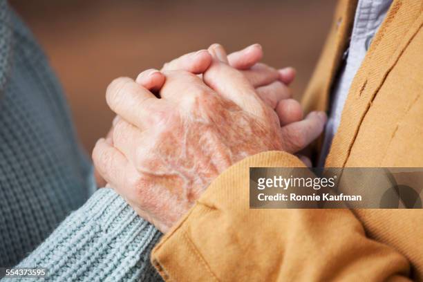 close up of older couple holding hands - holding hands close up stock-fotos und bilder