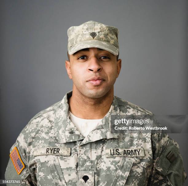 close up of mixed race soldier smiling - mixed race man standing studio stockfoto's en -beelden
