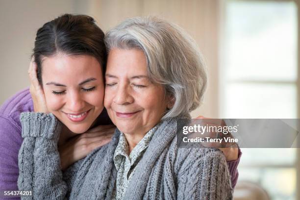 close up of smiling mother and daughter hugging - old man close up stock-fotos und bilder