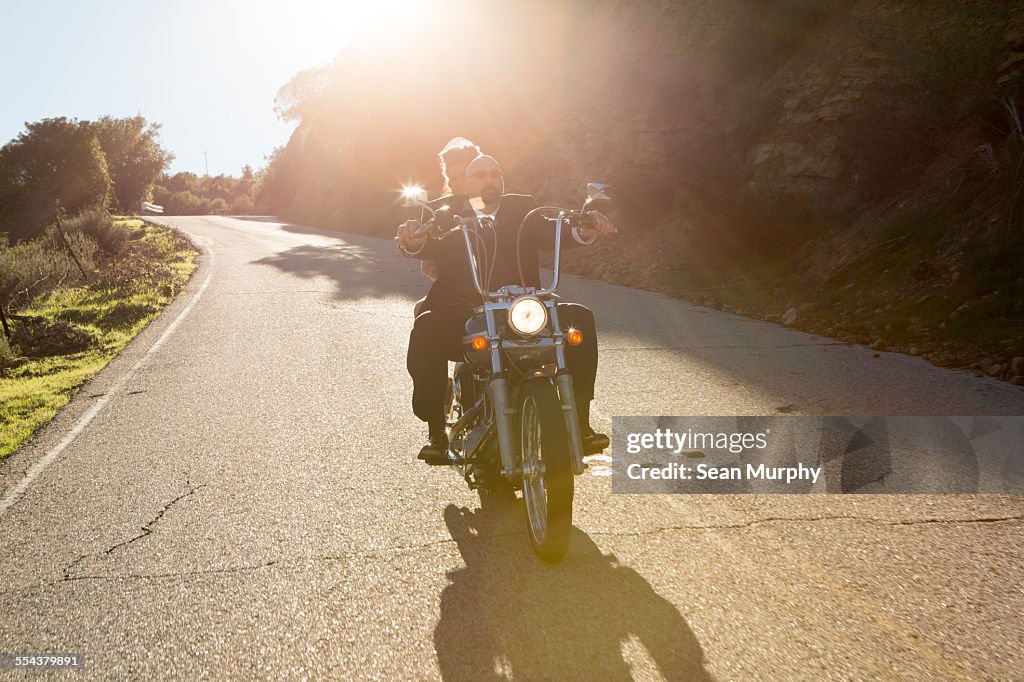 Newly-Weds Riding Motorcycle into the Sunset