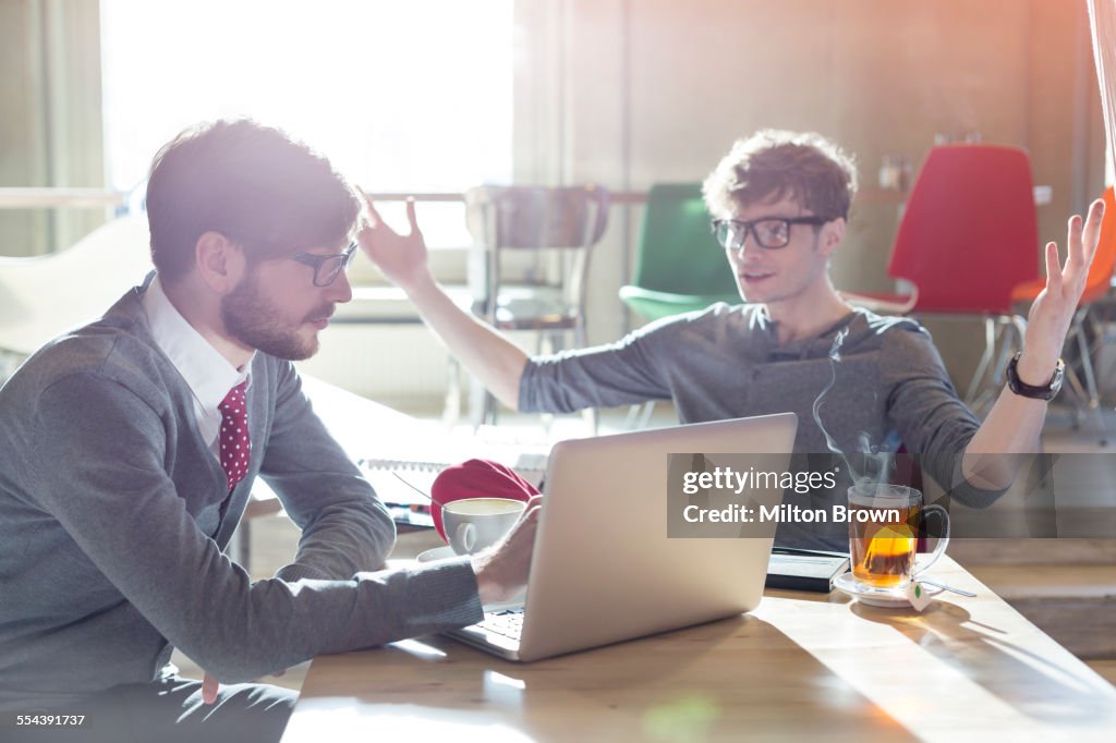 Casual businessmen using laptop in cafe