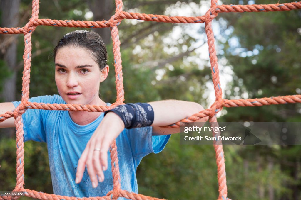 Portrait of confident woman leaning on net at boot camp