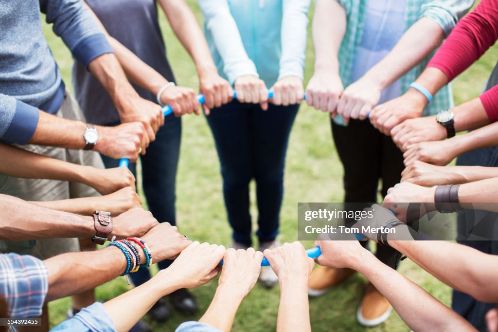 Team connected in circle around plastic hoop