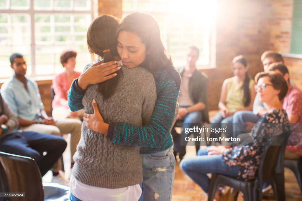 Mujeres abrazando en sesión de terapia de grupo