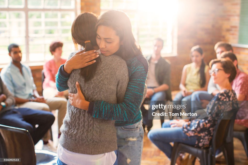 Women hugging in group therapy session