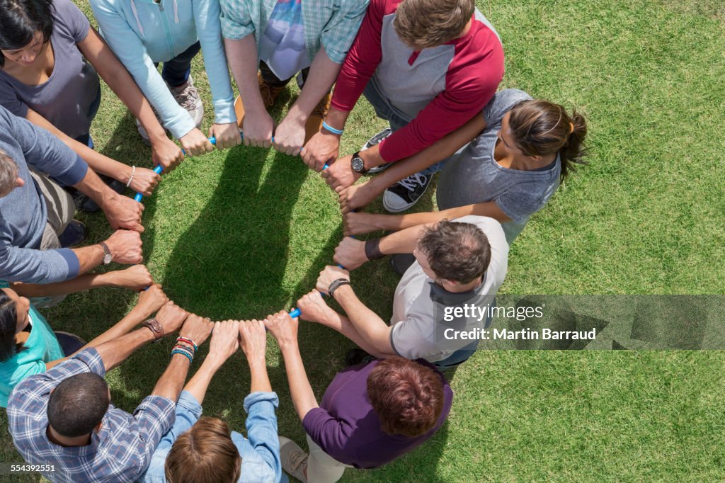 Group connected in circle around plastic hoop