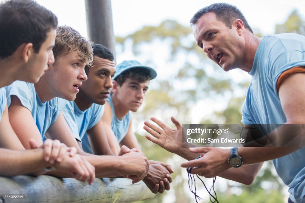 Team leader motivating team at boot camp obstacle course