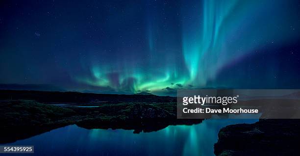 aurora over the silfra rift in iceland - noorderlicht stockfoto's en -beelden