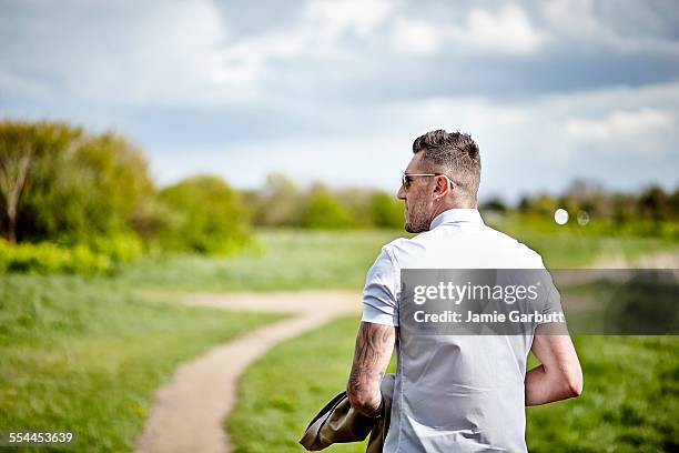 early 30's male taking a walk in the countryside - back tattoo stock pictures, royalty-free photos & images