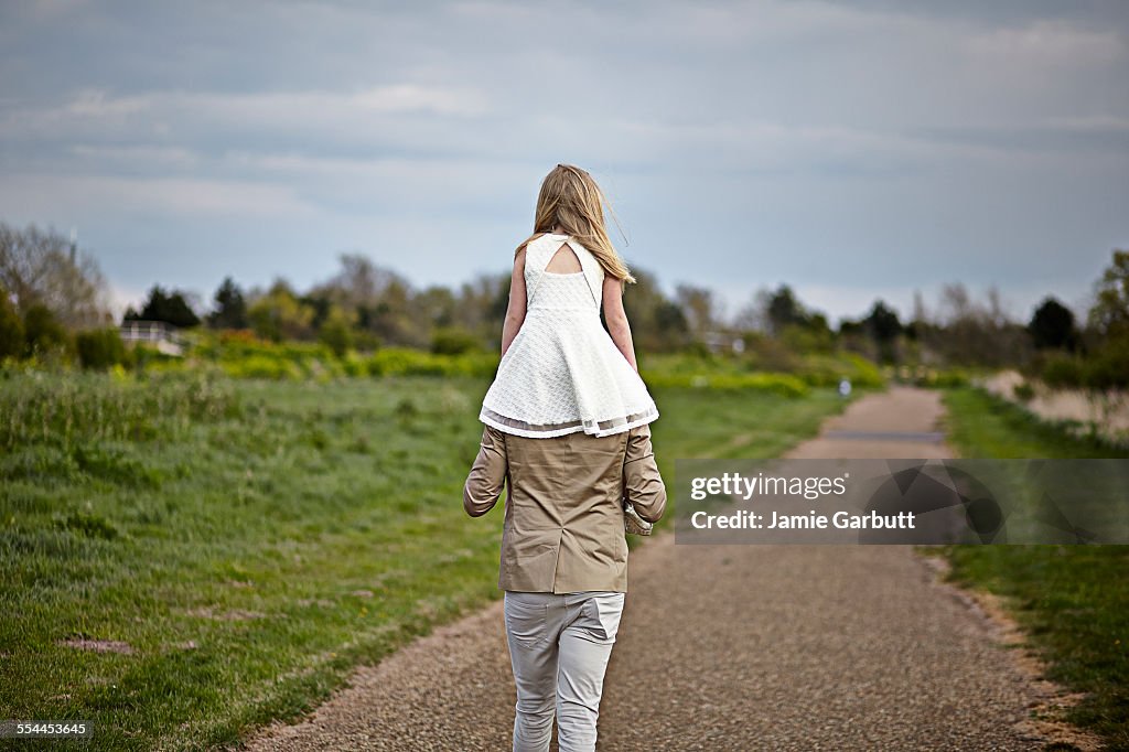 Early 30's male with his daughter on his shoulders