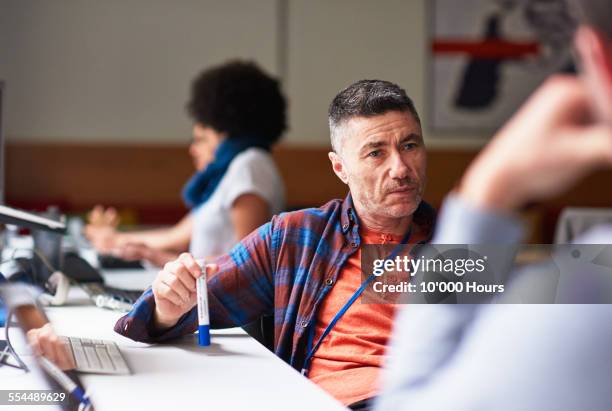 colleagues discussing plan in tech start-up office - mature men office stock pictures, royalty-free photos & images