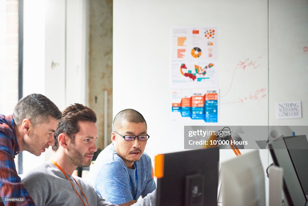Businessmen at computer in tech start-up office