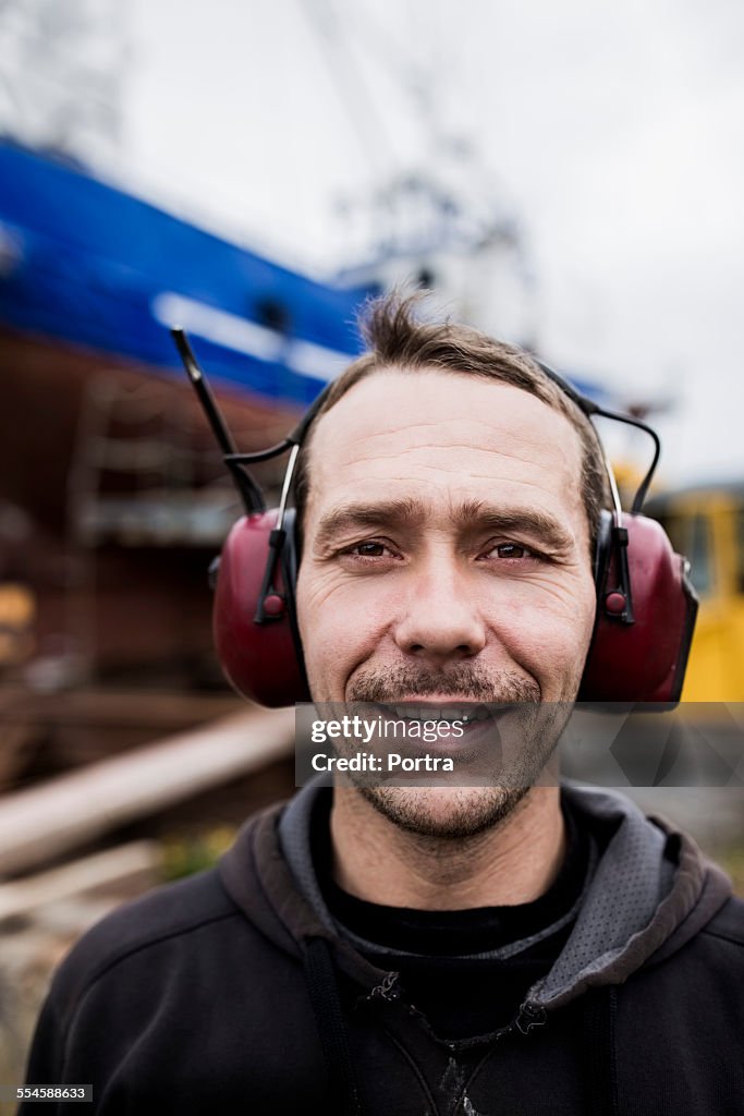 Worker wearing ear protectors at harbor