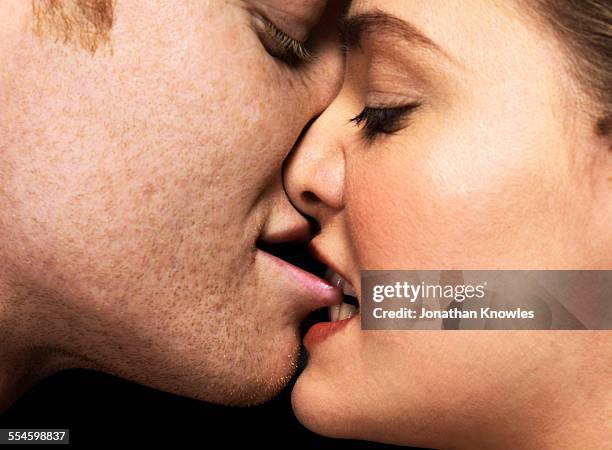 woman biting man's lips, close up - sinnlichkeit stock-fotos und bilder