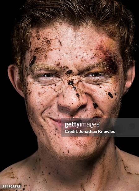 mud spattered over man's face - rugby portraits stock-fotos und bilder