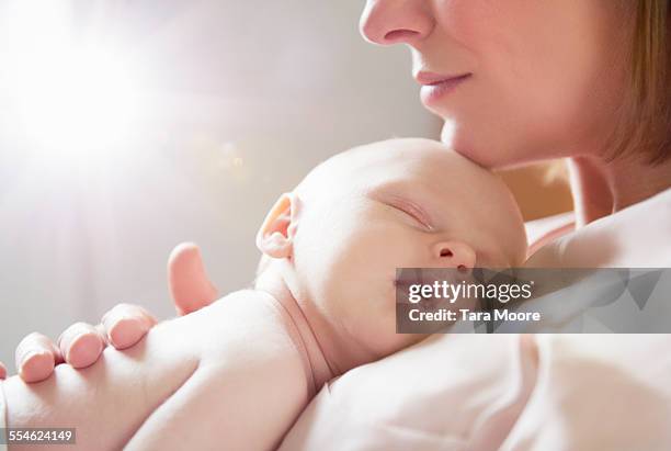 baby sleeping on mother's chest - mom holding baby stock-fotos und bilder