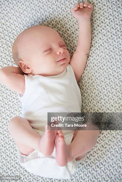 baby sleeping holding arm up - newborn sleeping stock pictures, royalty-free photos & images