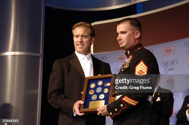 Former Denver Broncos quarterback John Elway presents the U.S. Marine Corps award to Staff Sergeant Matthew T. Anderson at the USO Gala honoring...