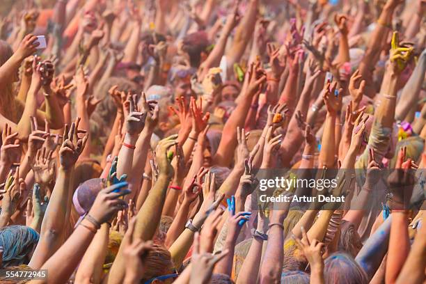 people with hands up of barcelona holi festival. - telephoto lens stock pictures, royalty-free photos & images