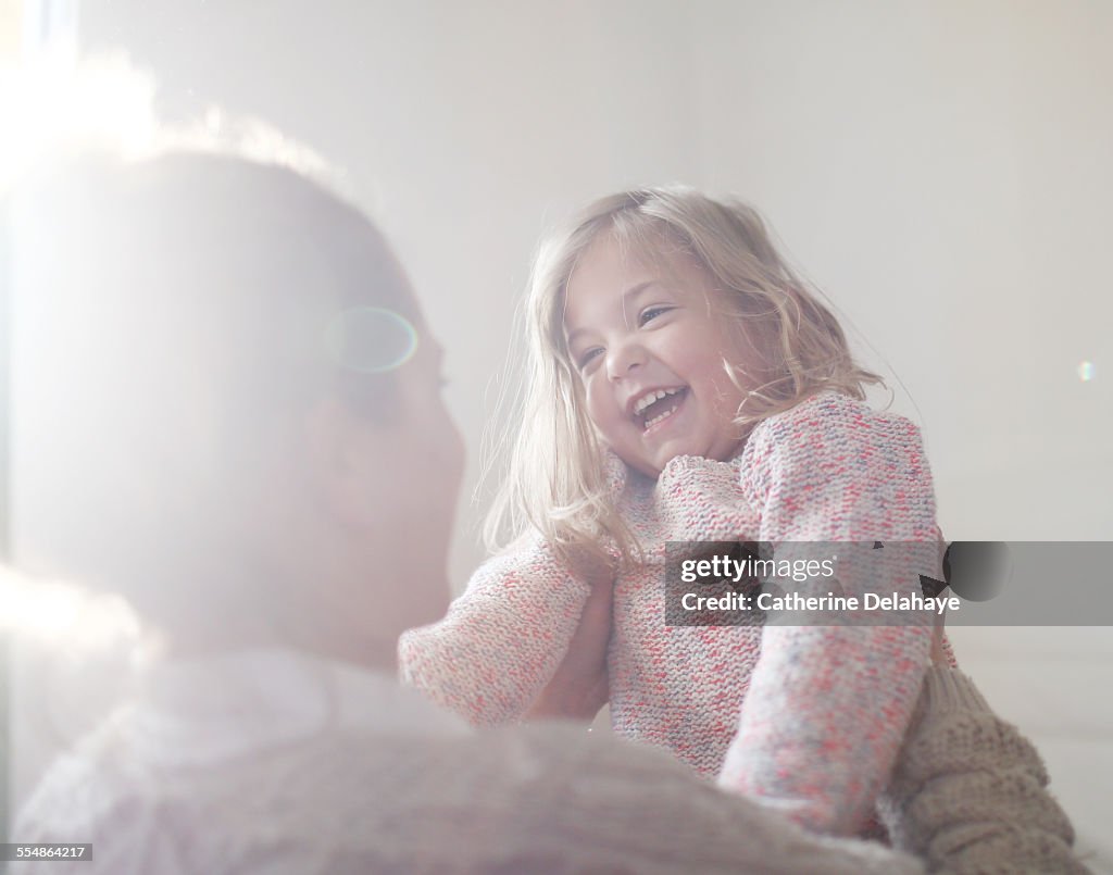 A 3 years old girl smiling to her mum