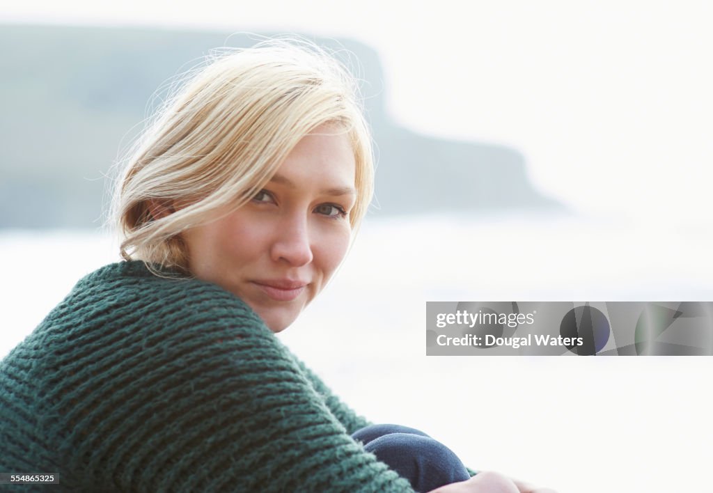 Woman sitting at beach, close up.
