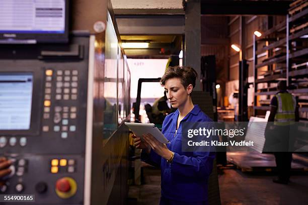 female steel worker holding tablet inside factory - técnica de fotografia imagens e fotografias de stock