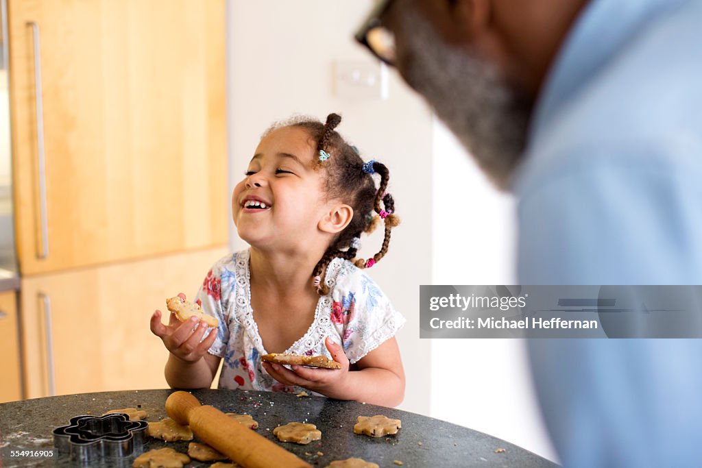 Young girl eating cookie and laughing