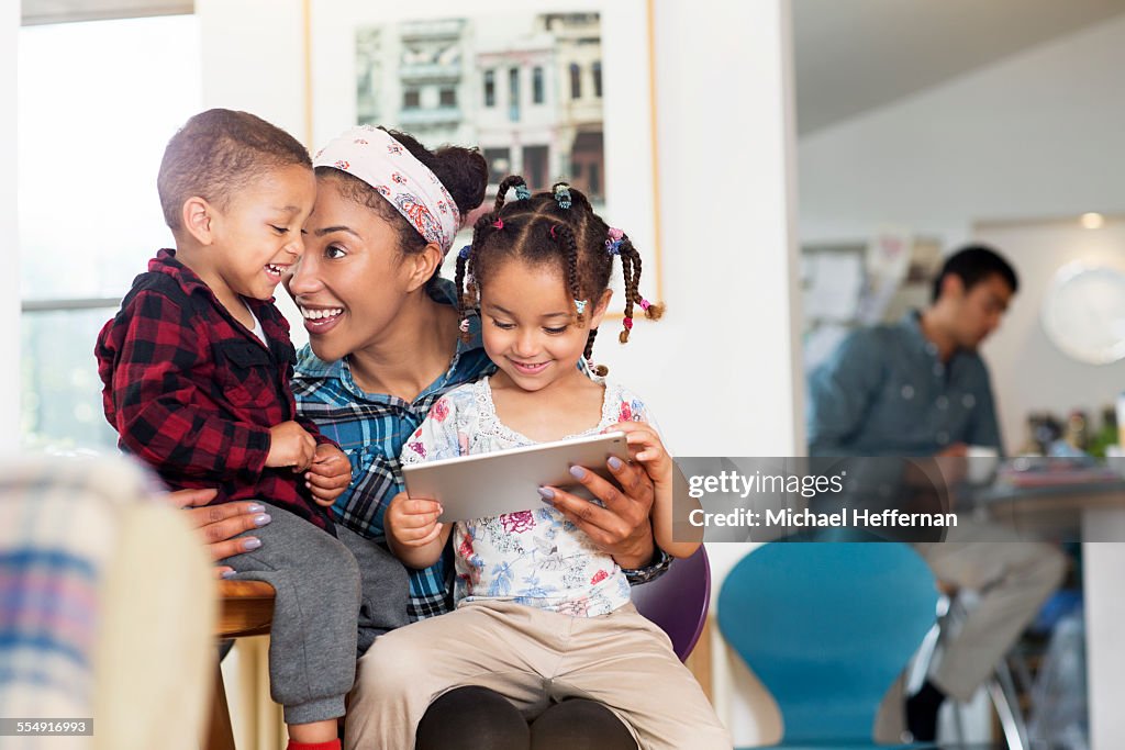 Mother, son and daughter having fun with tablet